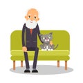 On the couch sit an elderly man and a cat. Portrait of elderly with animal. Lonely pensioner at home on vacation with a pet. Royalty Free Stock Photo