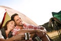 We could stay out here forever. A happy couple admiring nature while sitting by their tent. Royalty Free Stock Photo