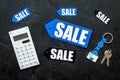 Count the benefits from the sale. Word sale on label near calculator on black background top view Royalty Free Stock Photo