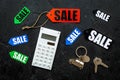 Count the benefits from the sale. Word sale on label near calculator on black background top view Royalty Free Stock Photo
