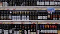 A counter with a large selection of wines. A collection of wines in an elite alcohol store. Bottles of various wines on