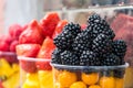 Counter with plastic containers and cups filled of fresh berries. Blackberry, strawberry, blueberry Royalty Free Stock Photo