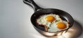Counter view of a frying pan with two fried eggs on a light background. Royalty Free Stock Photo
