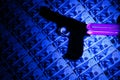 Counterfeit money checking with ultraviolet lamp. Fraud crime. Gun weapon Royalty Free Stock Photo