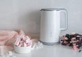 On the countertop of a bright marshmallow kitchen next to a white electric kettle and a bouquet of flowers Royalty Free Stock Photo