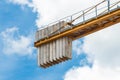 A counterweight of concrete blocks on the tail of a tower crane industrial equipment against a blue sky. Close-up Royalty Free Stock Photo