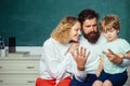 Counting on fingers. Happy young couple who are standing with their son at graduation. First time to school. First day