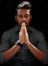 Counting his blessings. Shot of a focused young man standing with his hands together and praying with his eyes closed. Royalty Free Stock Photo