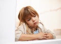 Counting the raindrops. a bored-looking little girl sitting and looking out a window on a rainy day. Royalty Free Stock Photo