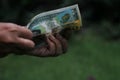 Counting money in hand. Payment day & financial budgeting concept on green background.