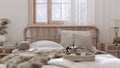 Country bed close up. Boho chic bedroom with rattan furniture, fur blanket, pillows, duvet and decors in white and bleached wood