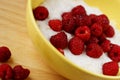 A country breakfast with pile of ripe raspberries, and porridge