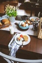 Country breakfast on rustic home kitchen with farm eggs, butter, wholegrain bread and milk.