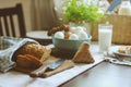 Country breakfast on rustic home kitchen with farm eggs, butter, wholegrain bread and milk.