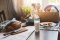 country breakfast on rustic home kitchen with farm eggs, butter, wholegrain bread and milk.