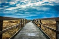 Country bridge located in the middle of a fall field under the cloudy sky