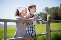 Country couple of farmers drink milk in field near fenc Royalty Free Stock Photo