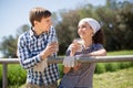 Country couple of farmers drink milk in field near fenc Royalty Free Stock Photo