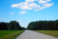 Country dirt road in the countryside. Rural crops grow along the road Royalty Free Stock Photo