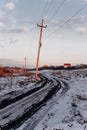 Country dirt road with muddy puddles and melting snow in early spring at sunset Royalty Free Stock Photo