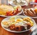 Country fried steak with sunny side up eggs and biscuits