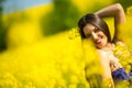 Country girl in a good mood walks in a rape field