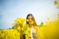 Country girl in a good mood walks in a rape field Royalty Free Stock Photo