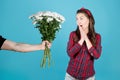 girl is pleasantly surprised, a man& x27;s hand holds out a bouquet of flowers to her Royalty Free Stock Photo