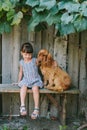 Country girl sitting on a bench with her dog under vine. wooden Royalty Free Stock Photo