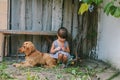 Country girl sitting on a bench with her dog under vine. wooden Royalty Free Stock Photo