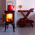 Country home design and interior with furnace. red kettle boiling on a retro stove in the kitchen. open fireplace. Focus