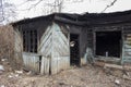 Country house after the fire. The skeleton of a burnt wooden house. Broken charred dwelling. Broken door windows, black walls