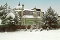 Landscape with snowbanks of white snow and pine trees in country garden.