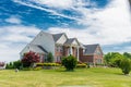 Country house in the suburbs of Leesburg, Virginia with a green lawn in the foreground. Blue sky, clear summer day