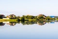 Country houses on the lake behind the trees, the reflection of houses in the water