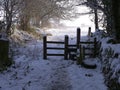 Country lane and stile in England covered in snow