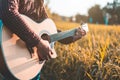 Country music, Man playing acoustic guitar in rice field Royalty Free Stock Photo