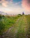 A country path leading to a windmill on a hill Royalty Free Stock Photo