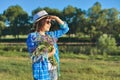 Country portrait of an adult beautiful woman in hat with bouquet of wildflowers Royalty Free Stock Photo