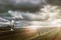 crash barrier on a country road in bright sunshine with sunbeams and a gloomy sky Royalty Free Stock Photo