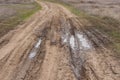 Country road. Autumn dirt road. Puddle and mud with deep ruts