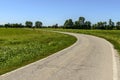 Country road bending among rice fields near Motta Visconti, Ital