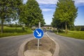 Country road with blue traffic sign Royalty Free Stock Photo