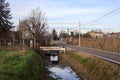 Country road bordered by a stream of water on a cloudy day in the italian countryside Royalty Free Stock Photo