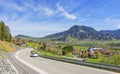 Country road with car and Gruenten mountain in spring. AllgÃÂ¤u, Bavaria, Germany