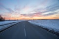 country road with curve in winter landscape, dreamy sunset sky, Brunnthal village, upper bavaria Royalty Free Stock Photo