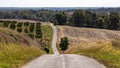 Country road through farm land and rolling hills Royalty Free Stock Photo