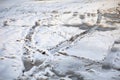 Traces of car ruts on dirt road covered with snow.