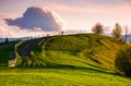 Country road through grassy hill at sunset Royalty Free Stock Photo