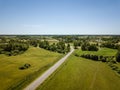country road in green forest and fields drone aerial image